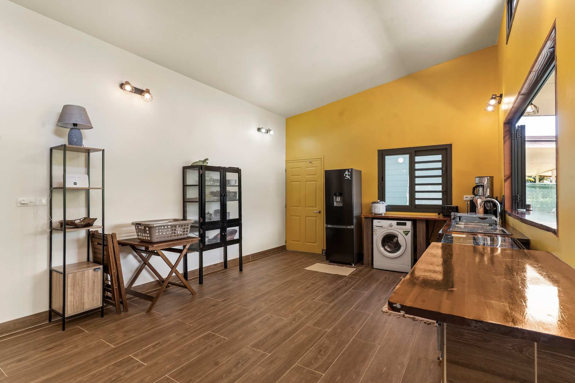 Komako, cuisine aux murs jaunes, frigo, lave-linge et plan en bois