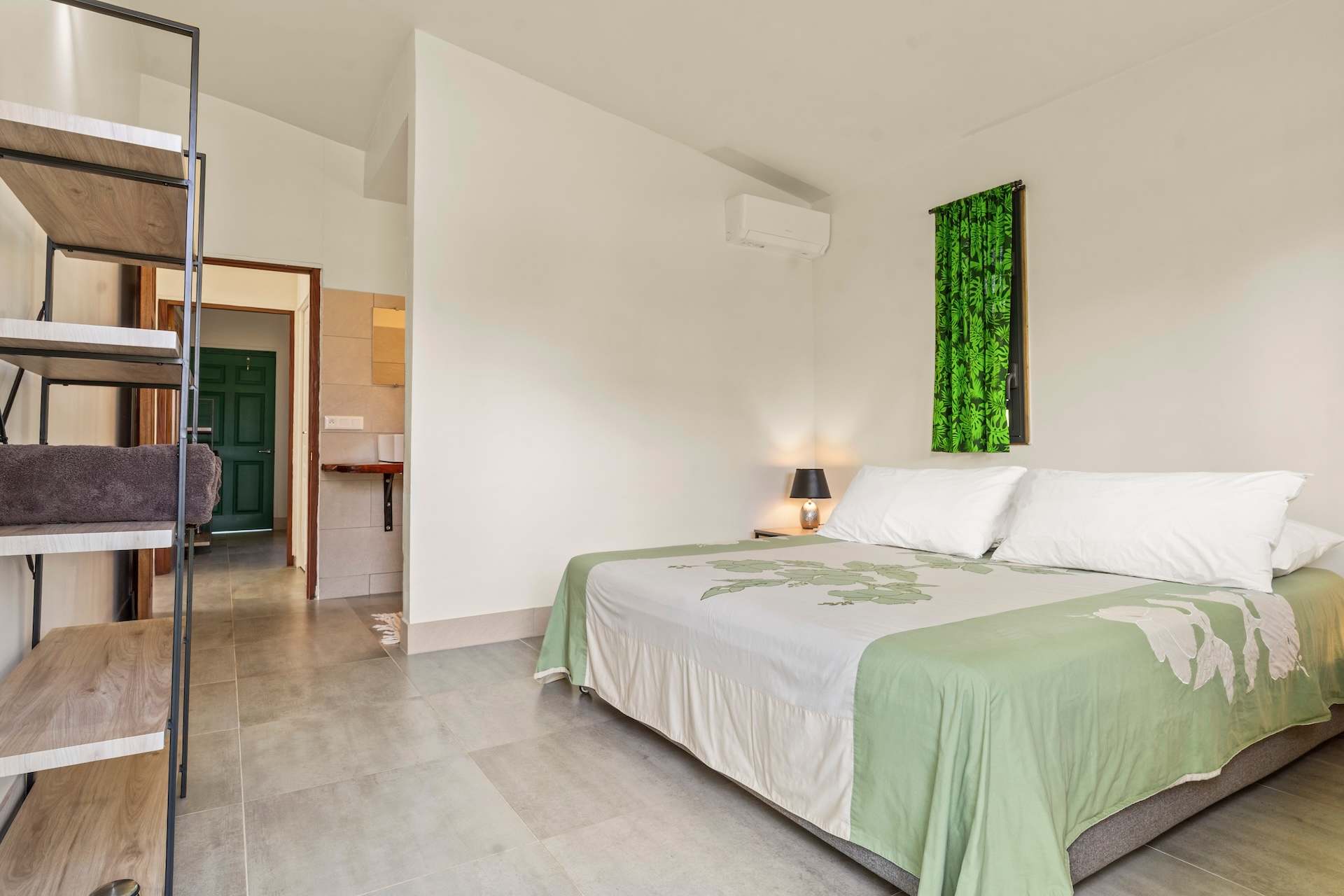 Pihiti, Schlafzimmer mit Kingsize-Bett, grüner polynesischer Tagesdecke und Klimaanlage
